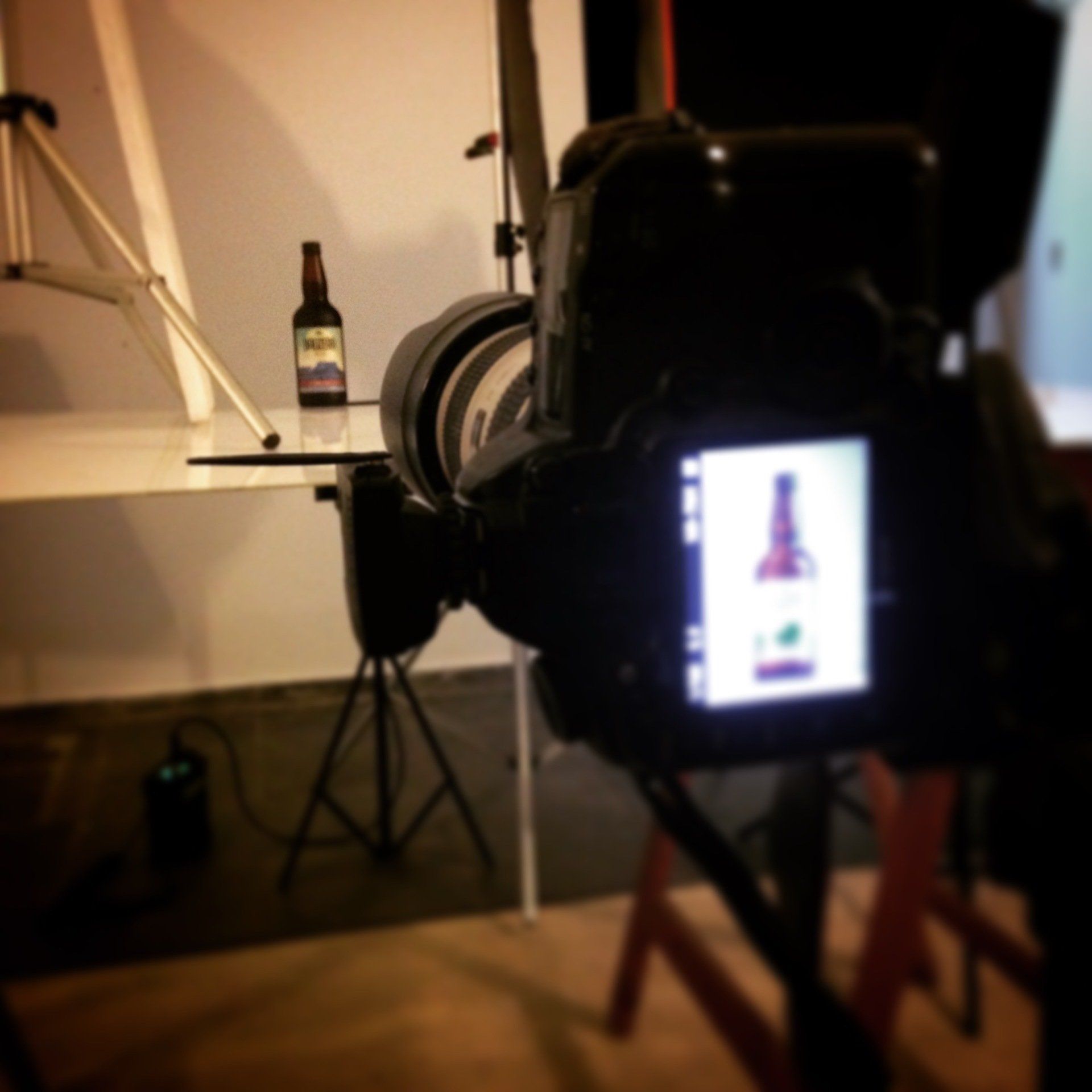 Uma câmera está tirando uma foto de uma garrafa de cerveja