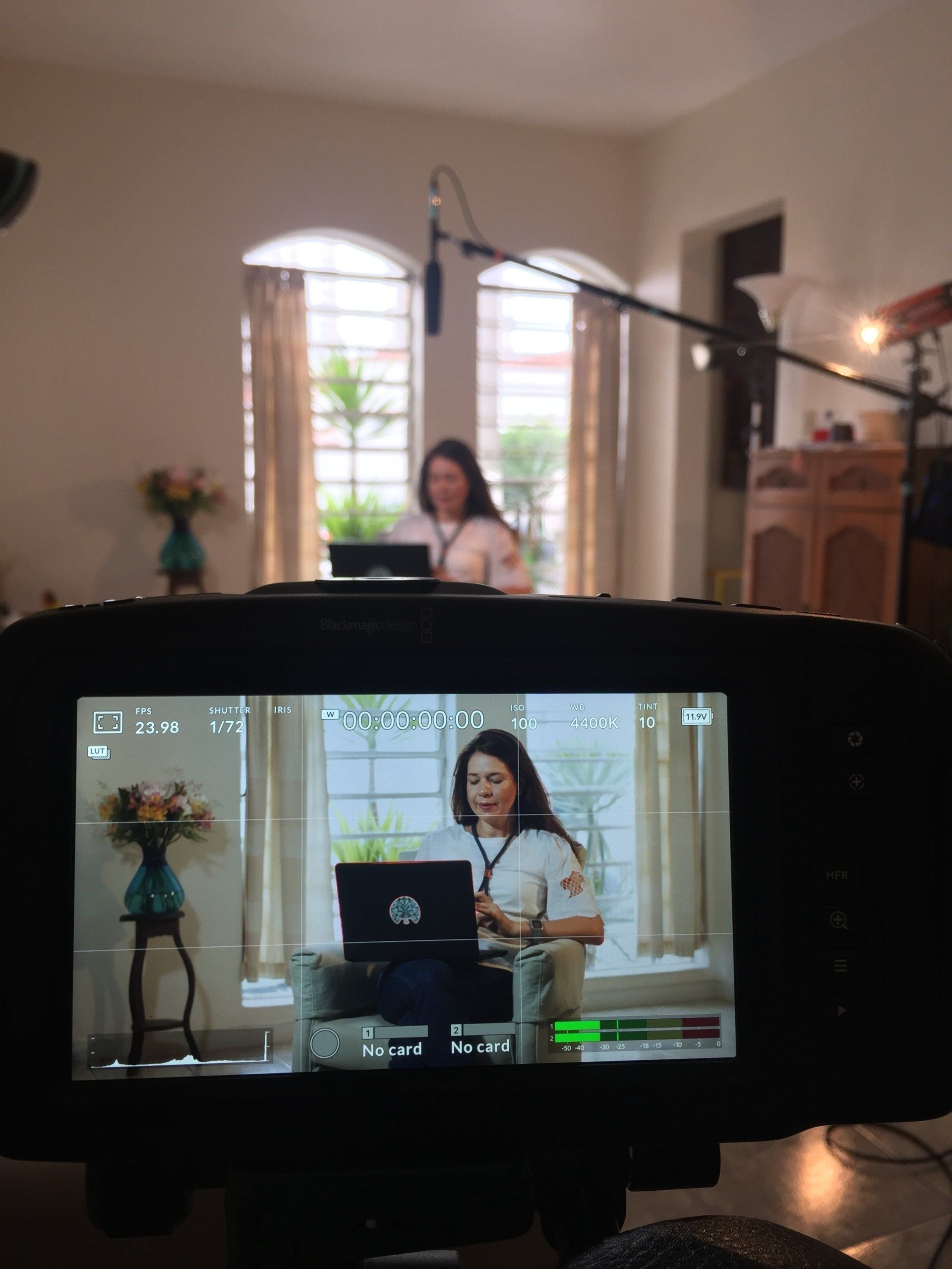 Uma mulher está sentada em frente a um laptop em uma sala de estar