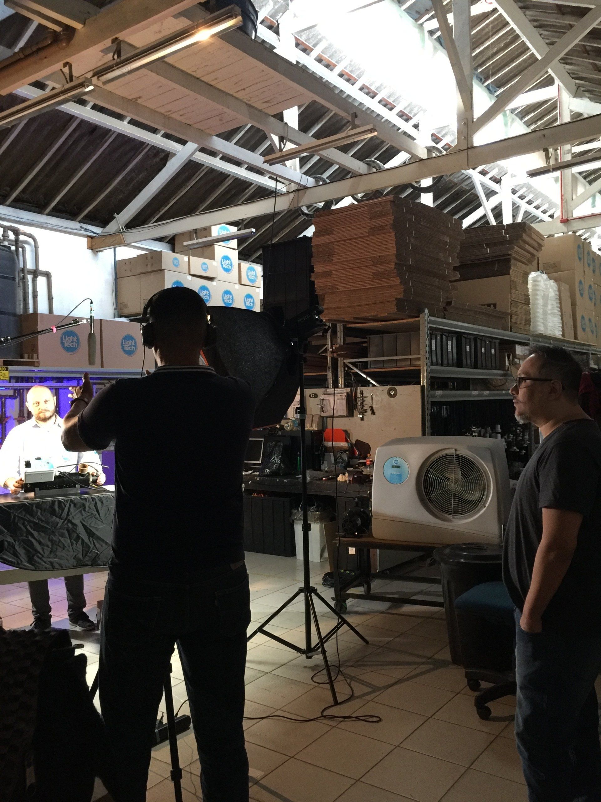 Um homem está parado em um armazém segurando uma luz.