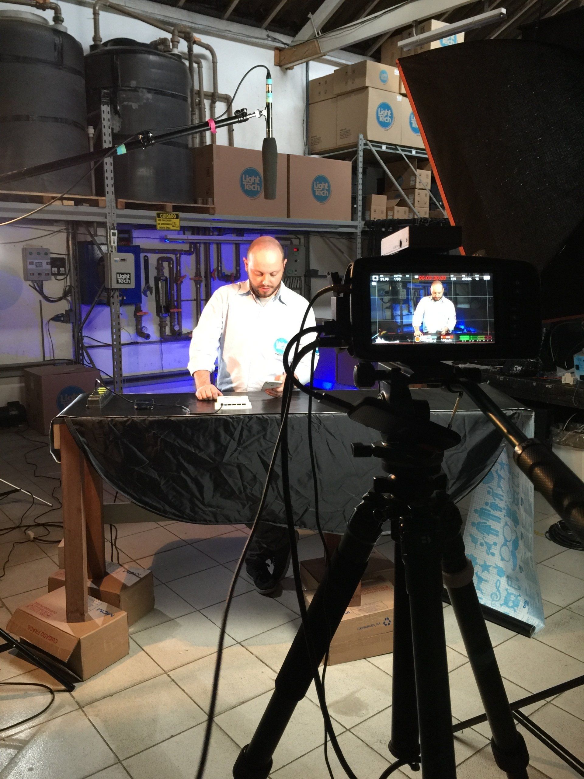 Um homem está sendo filmado por uma câmera em uma sala