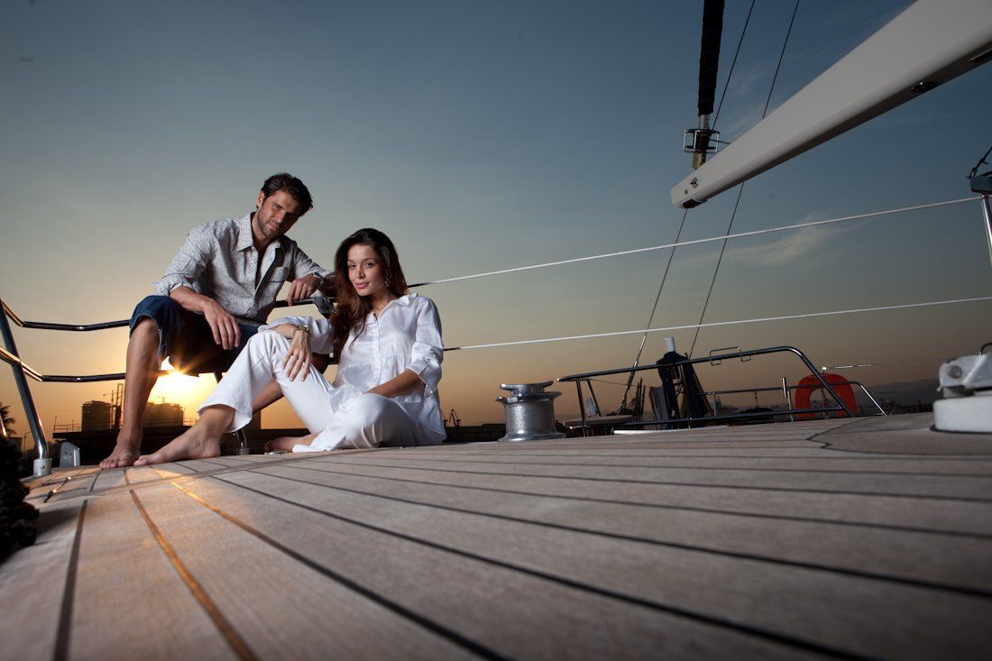 Um homem e uma mulher estão sentados no convés de um barco