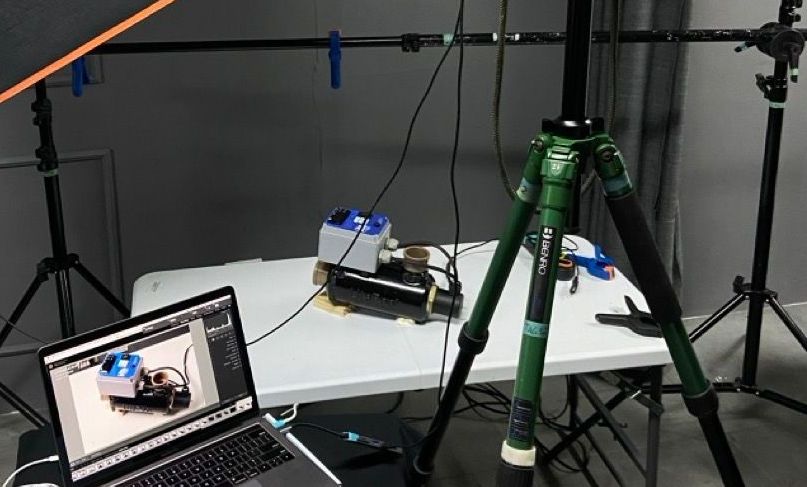 A laptop is sitting on a table next to a tripod.