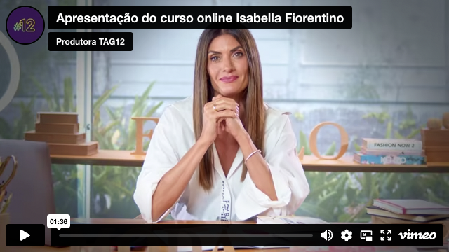 Uma mulher está sentada à mesa com as mãos cruzadas