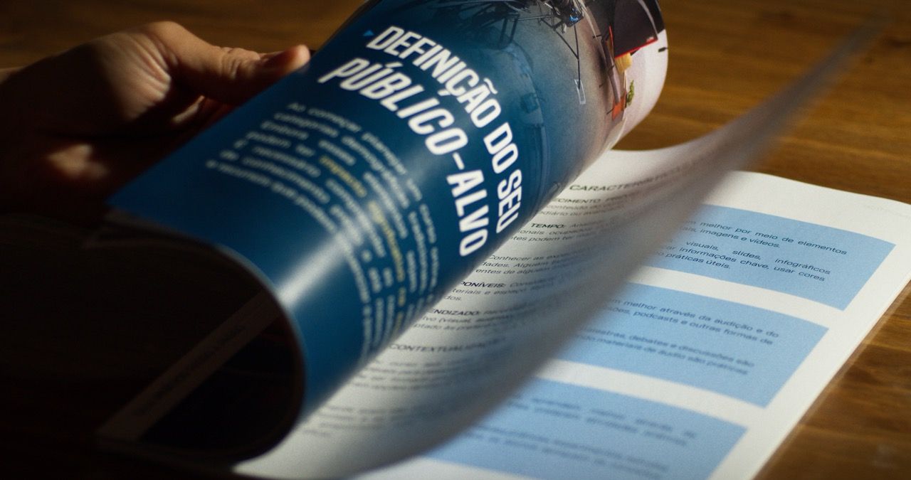 A person is holding a book that says definicao do publico-alvo