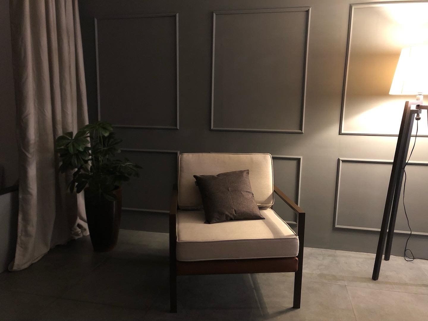 Uma sala de estar com uma cadeira e uma luminária