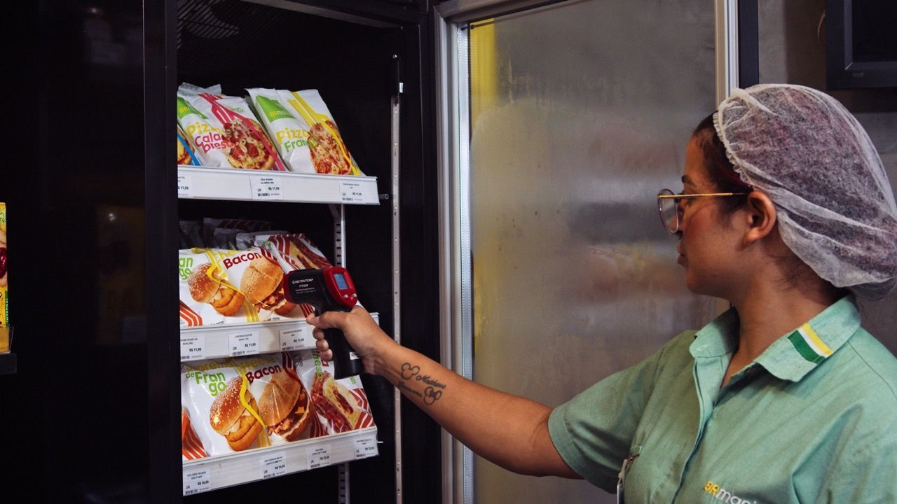 Uma mulher está parada na frente de uma máquina de venda automática.