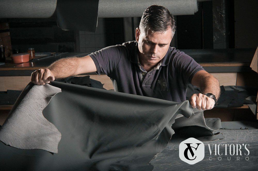 Um homem está segurando um pedaço de couro nas mãos.