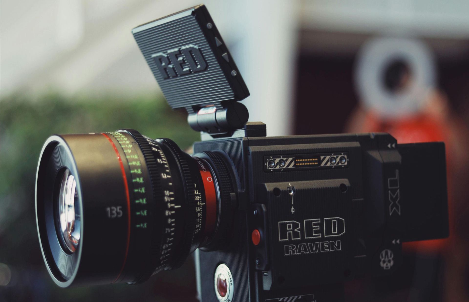 A close up of a cine camera with a person in the background