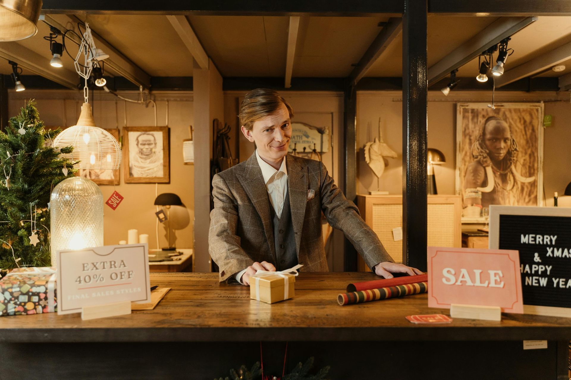 A man in a suit is standing behind a counter in a store.