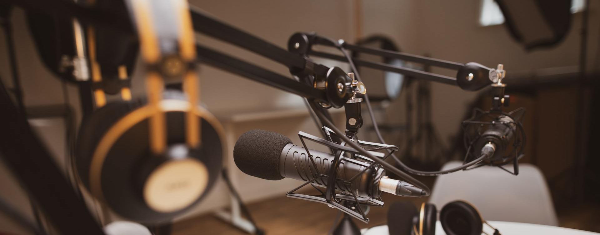 A microphone and headphones are sitting on a table in a recording studio.