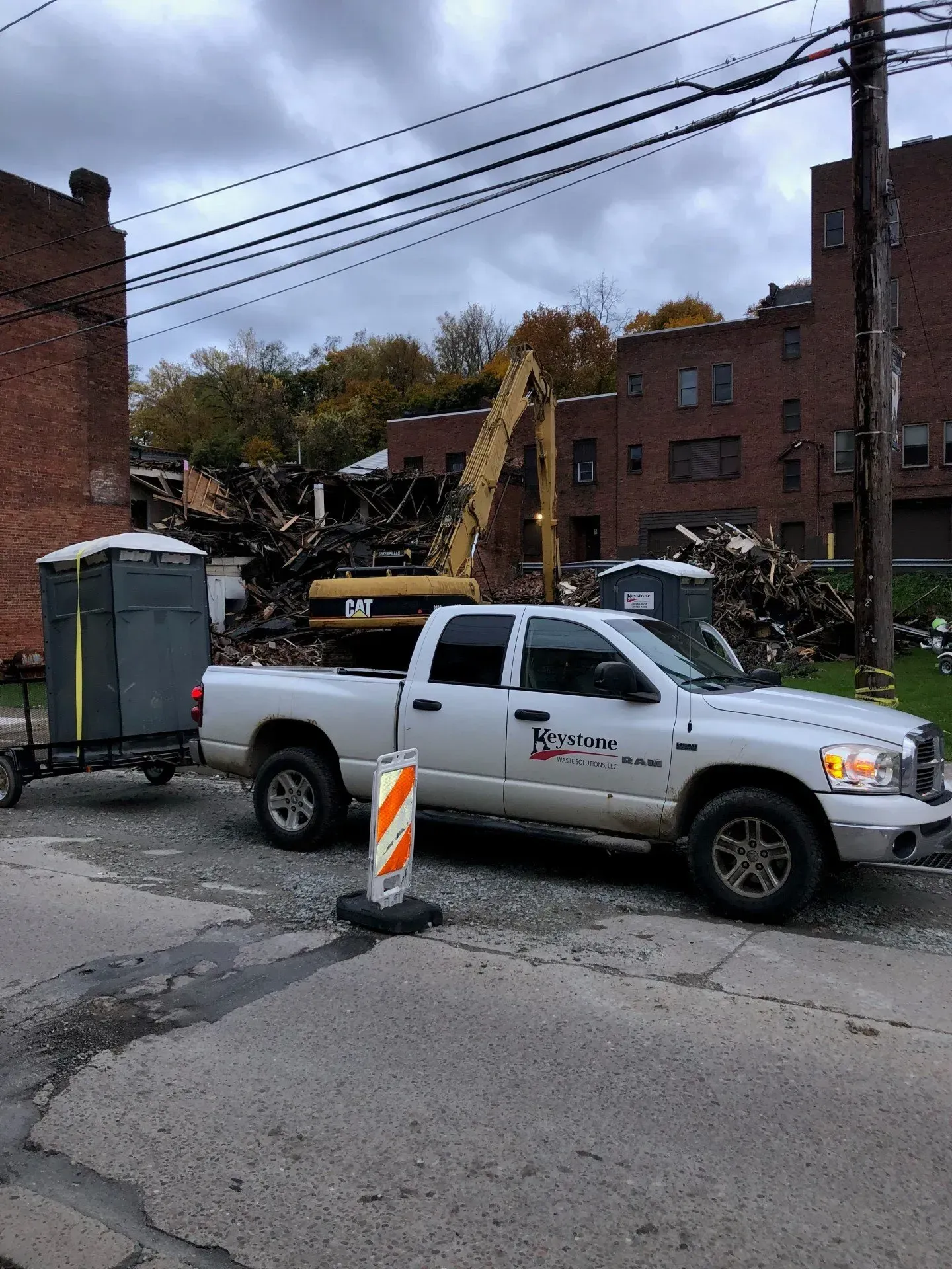 A white truck is parked on the side of the road next to a trailer.