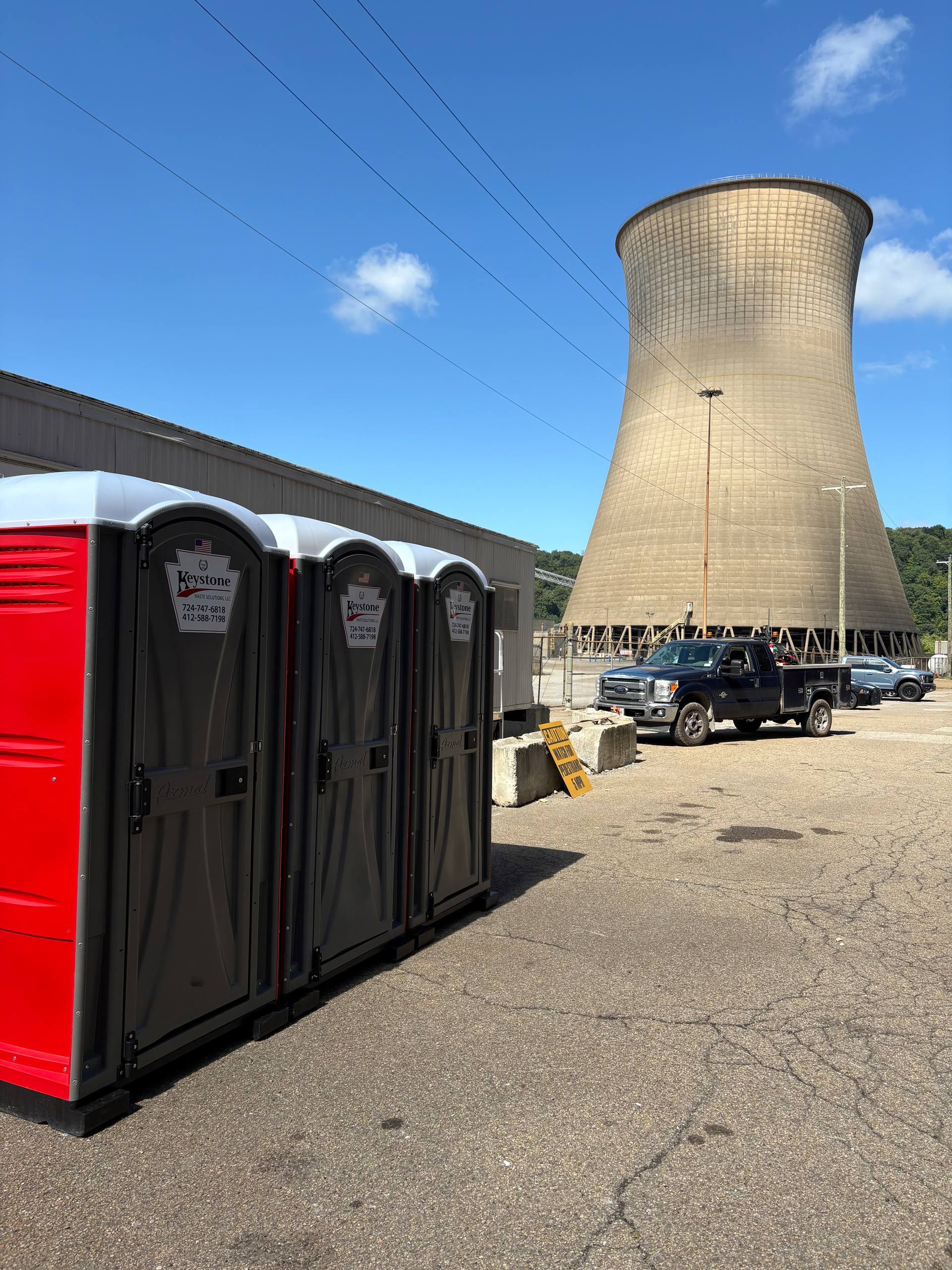 A portable toilet with an american flag in the background.