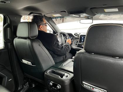 A man is sitting in the driver 's seat of a car.