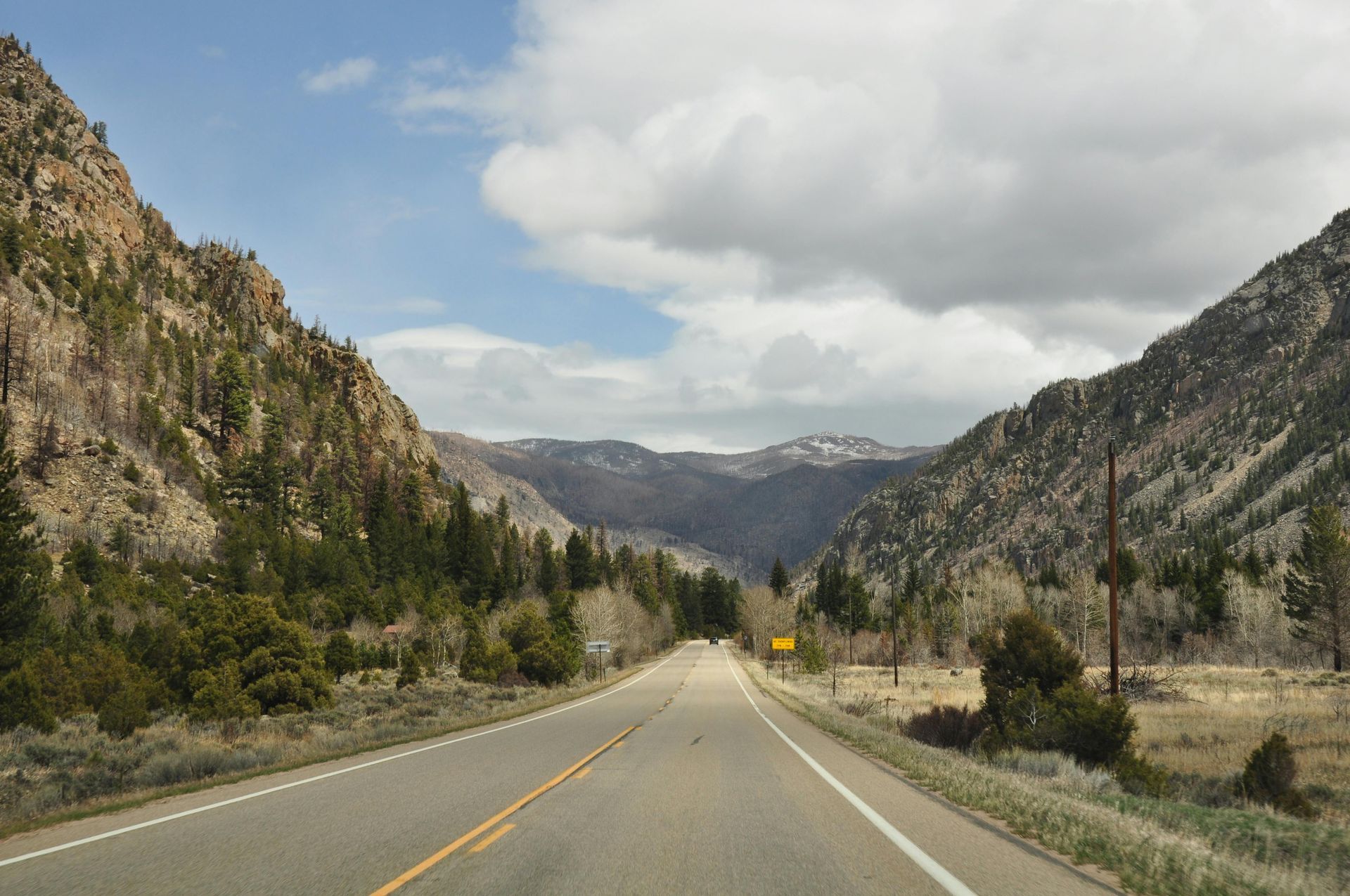 A road going through a valley with mountains in the background