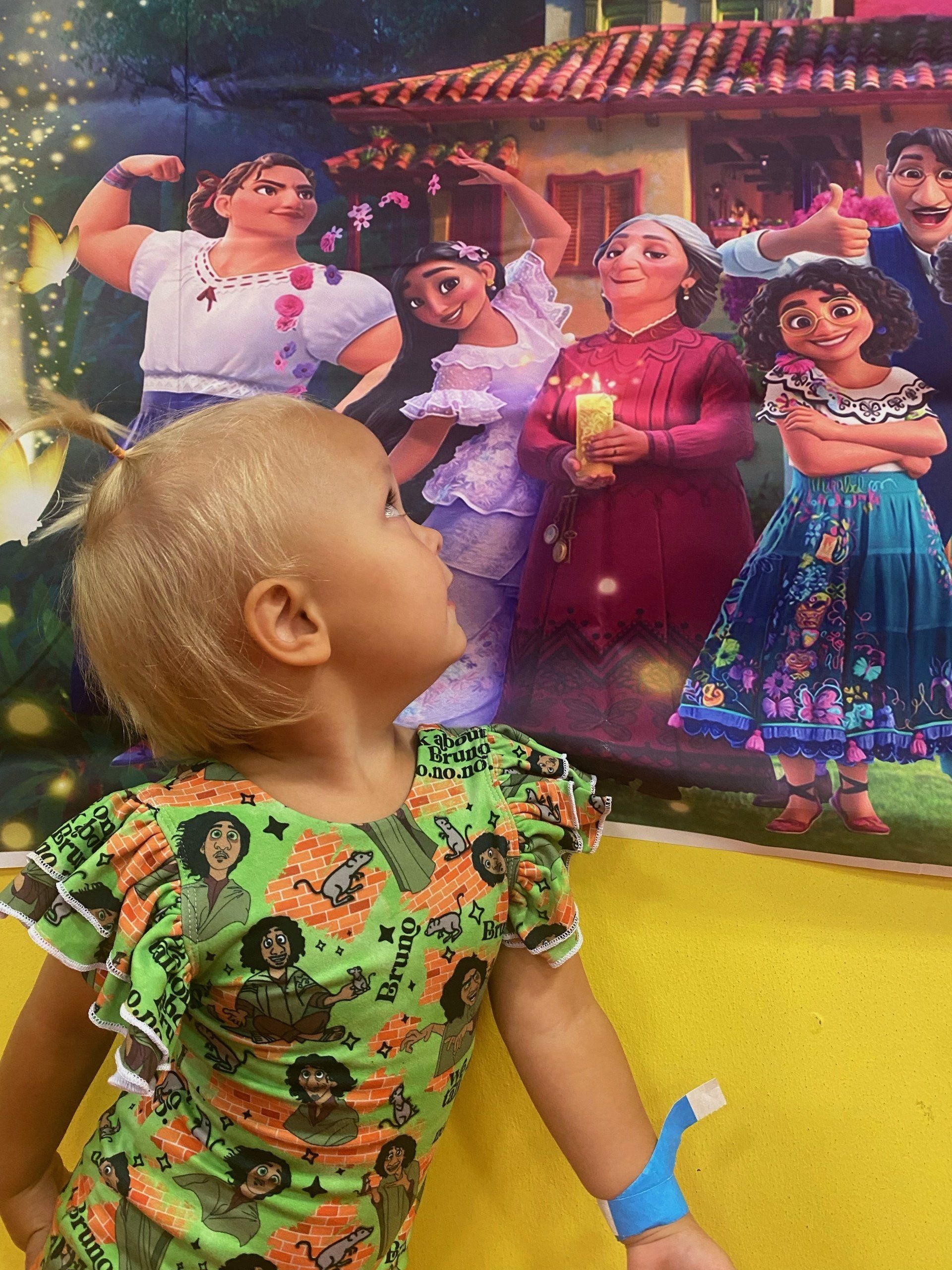 Girl in a green dress looks up at an