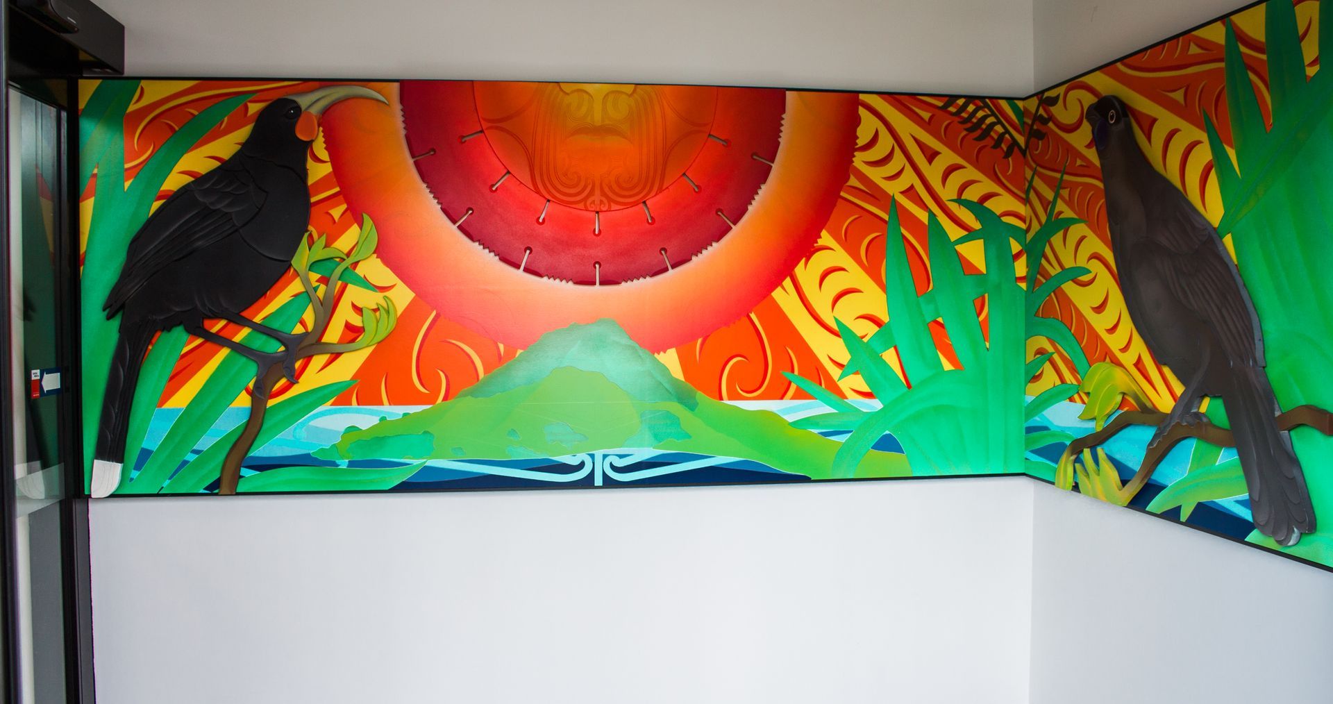 A painting of birds and a sun on a wall