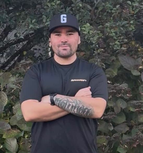 A man wearing a hat with the letter g on it