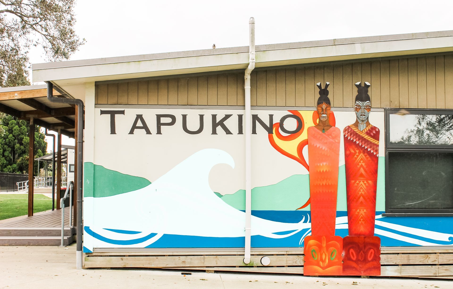 A mural on the side of a building that says tapukino