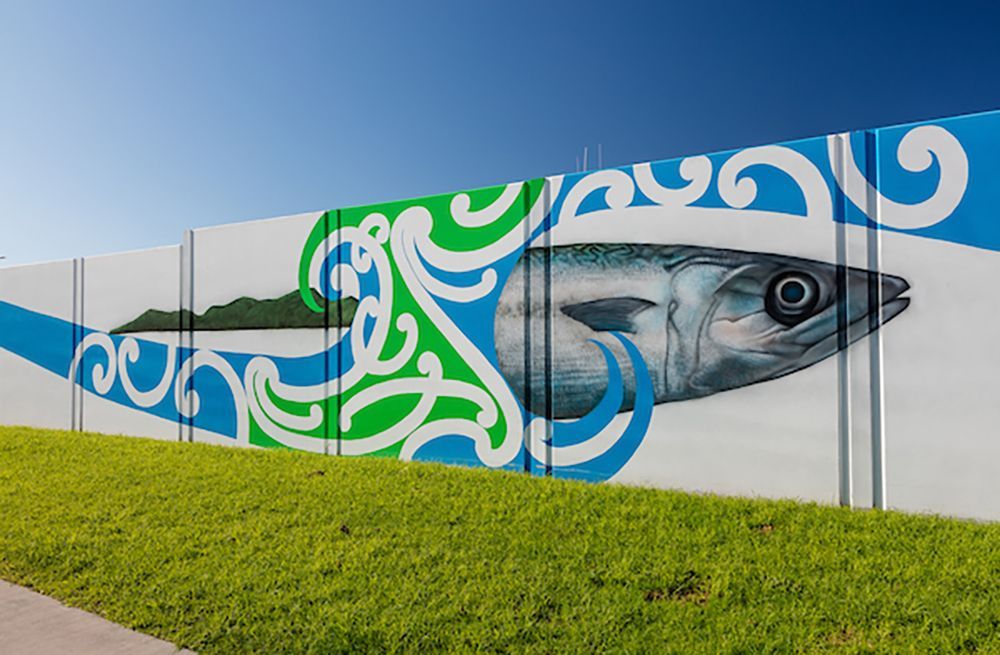 A fence with a painting of a fish on it.