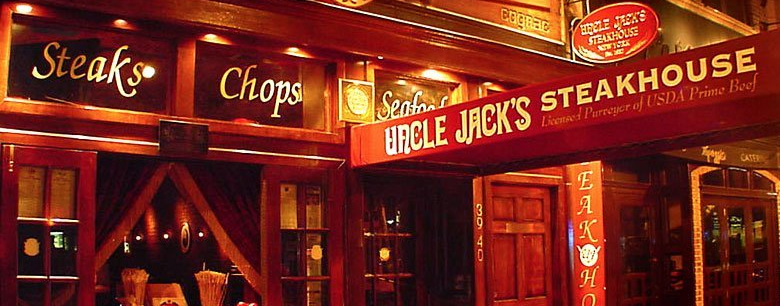 A restaurant called uncle jack 's steakhouse is lit up at night
