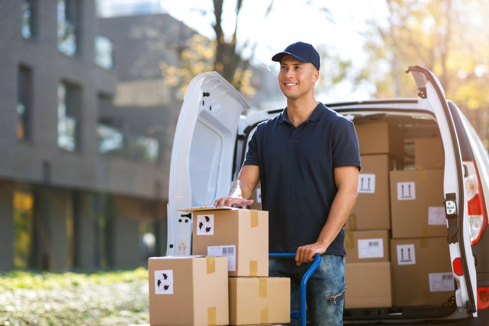 A Delivery Man Is Standing Next To A Van Filled With Boxes — Express City Couriers in Palm Cove, QLD