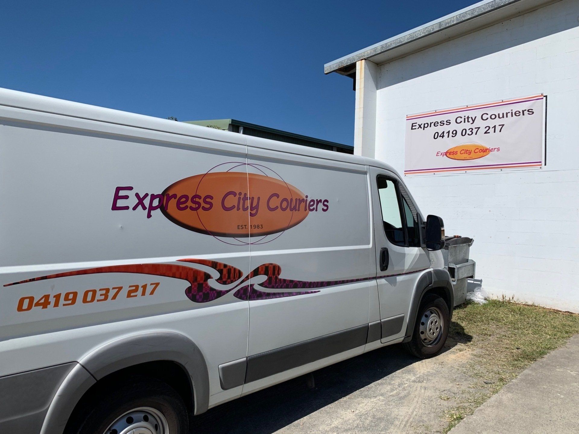 An Express City Courier Van Is Parked In Front Of A Building — Express City Couriers in Bungalow, QLD