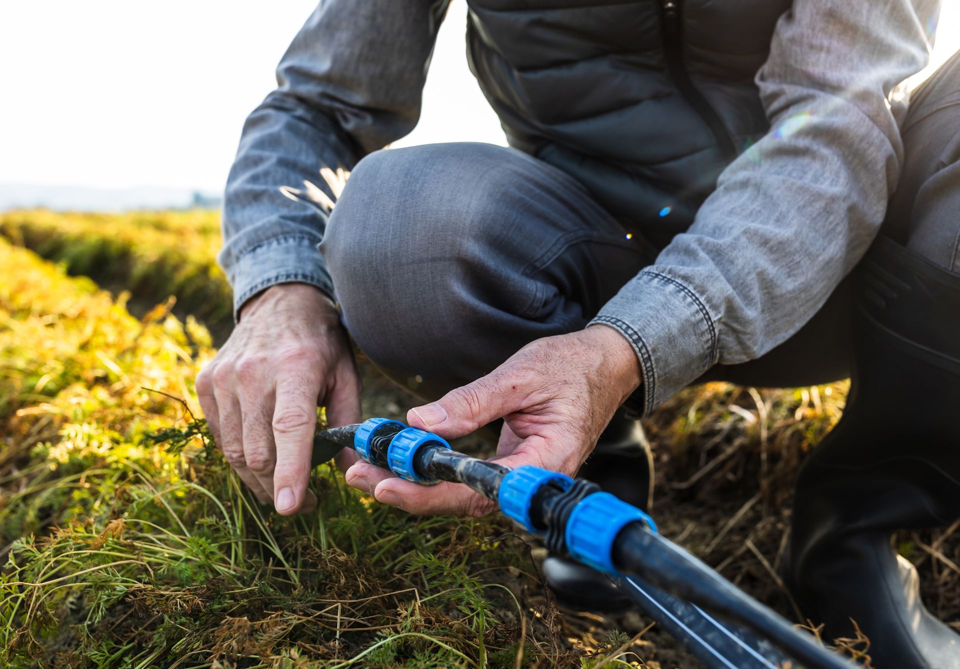 Farmer repairing irrigation system in field. Farmer repairing irrigation system in field.
