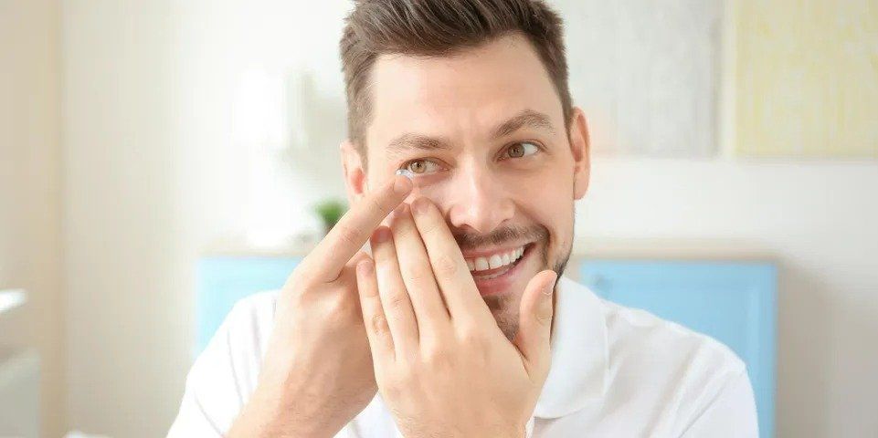 A man putting contact lense in his eyes  — New London, WI — Griebenow Eyecare Sc Clintonville