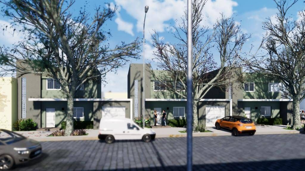 Hilera de casas adosadas con árboles, coches en la calle, cielo nublado.