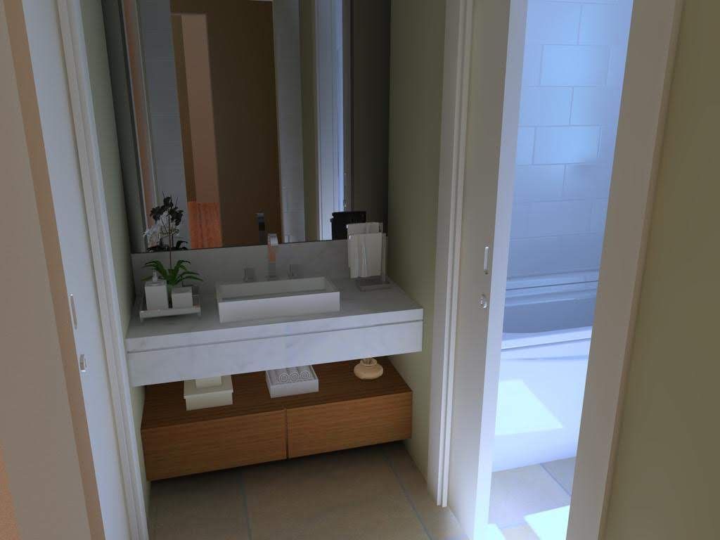 Baño con lavabo blanco, gabinetes marrones y puerta de ducha.