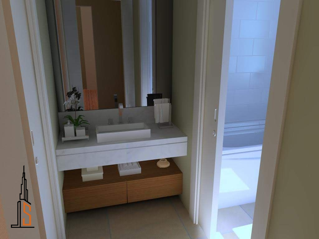 Baño con lavabo blanco, gabinetes marrones y puerta de ducha.