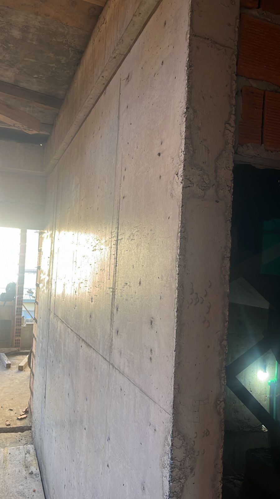 Muro de hormigón en construcción, vista lateral. Interior con mampostería visible.