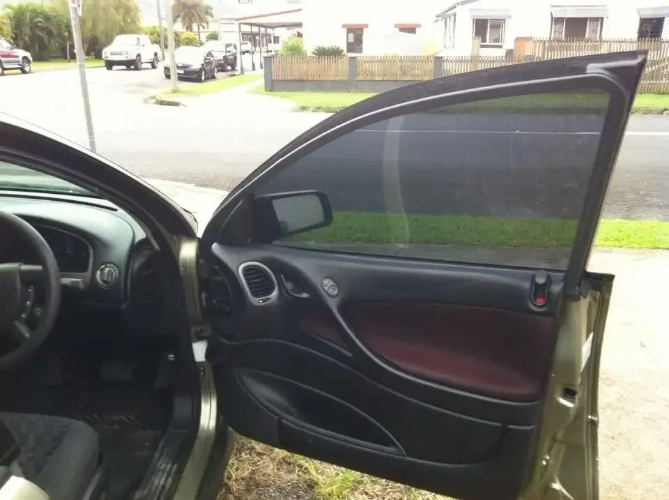 A Car With The Door Open Is Parked On The Side Of The Road — CQ Auto Tint In Kawana, QLD