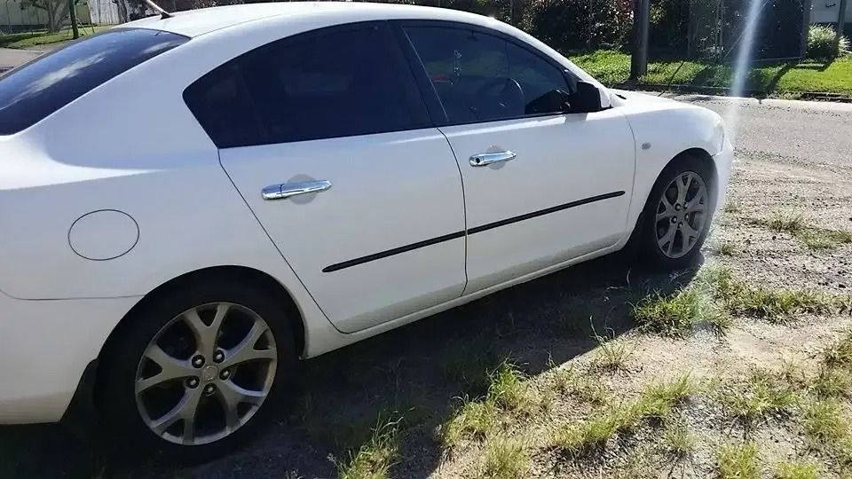 A White Car Is Parked In The Grass On The Side Of The Road — CQ Auto Tint In Kawana, QLD