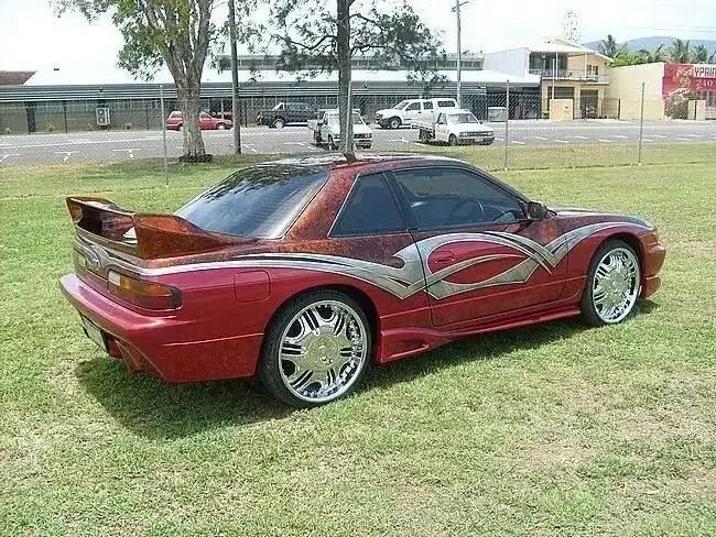 A Red Sports Car Is Parked In A Grassy Field — CQ Auto Tint In Kawana, QLD