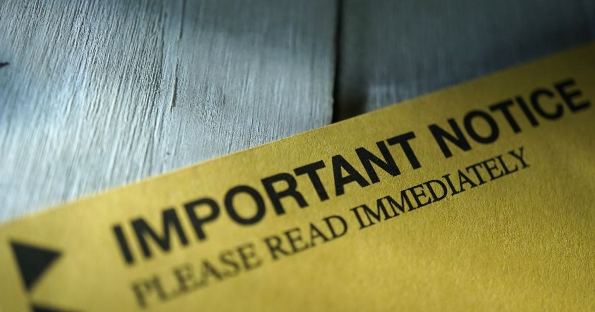 yellow paper that says 'important notice - please read immediately' on a wooden floor