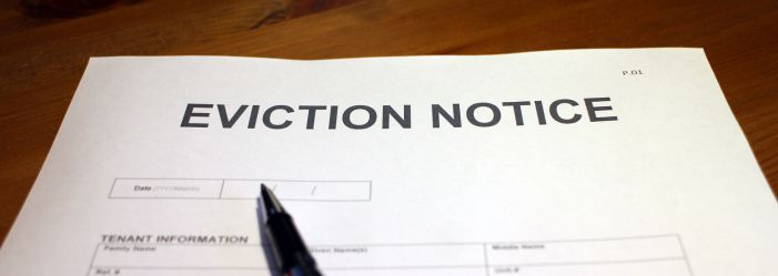 piece of paper on a wooden table that says eviction notice