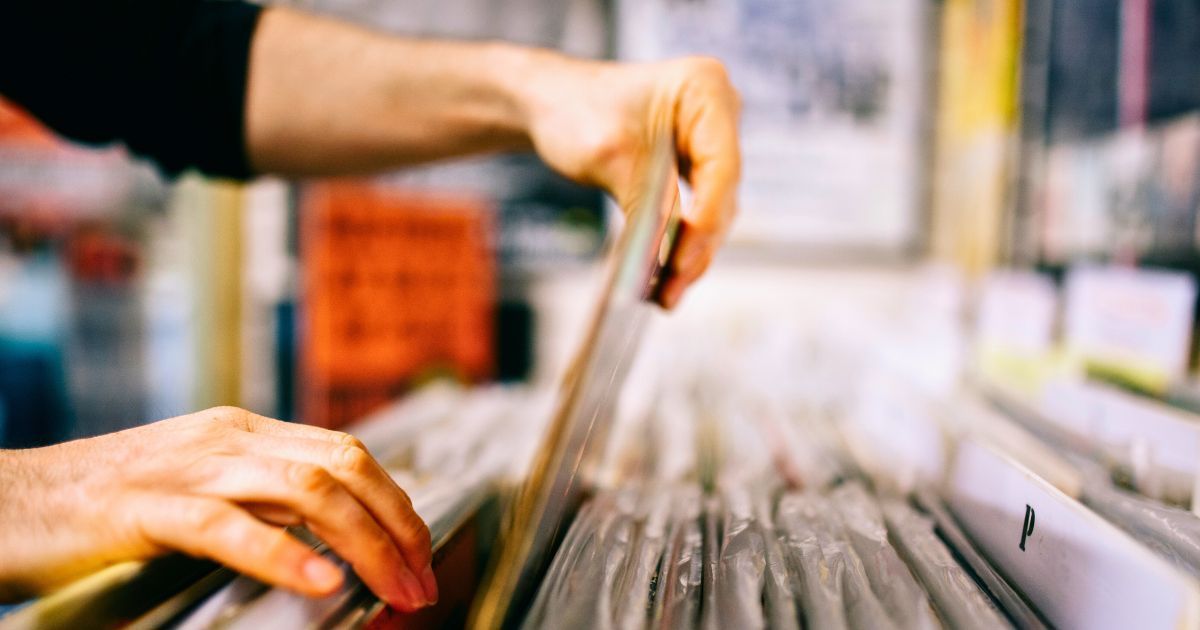person's hands in a filing cabinet, pulling out one file