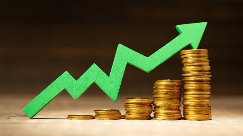 stacks of coins increasing with a line chart above showing the increase