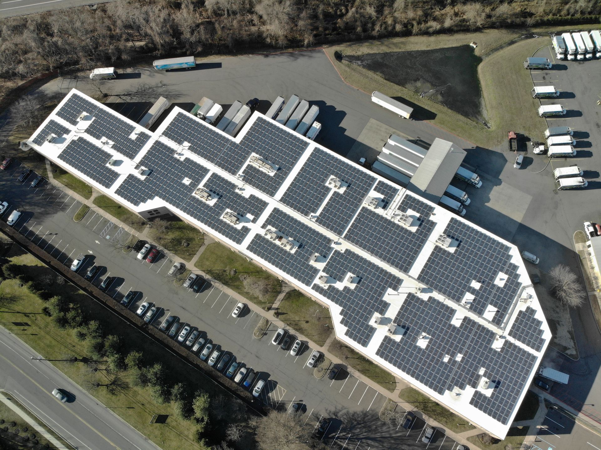 An aerial view of a large building with solar panels on the roof.