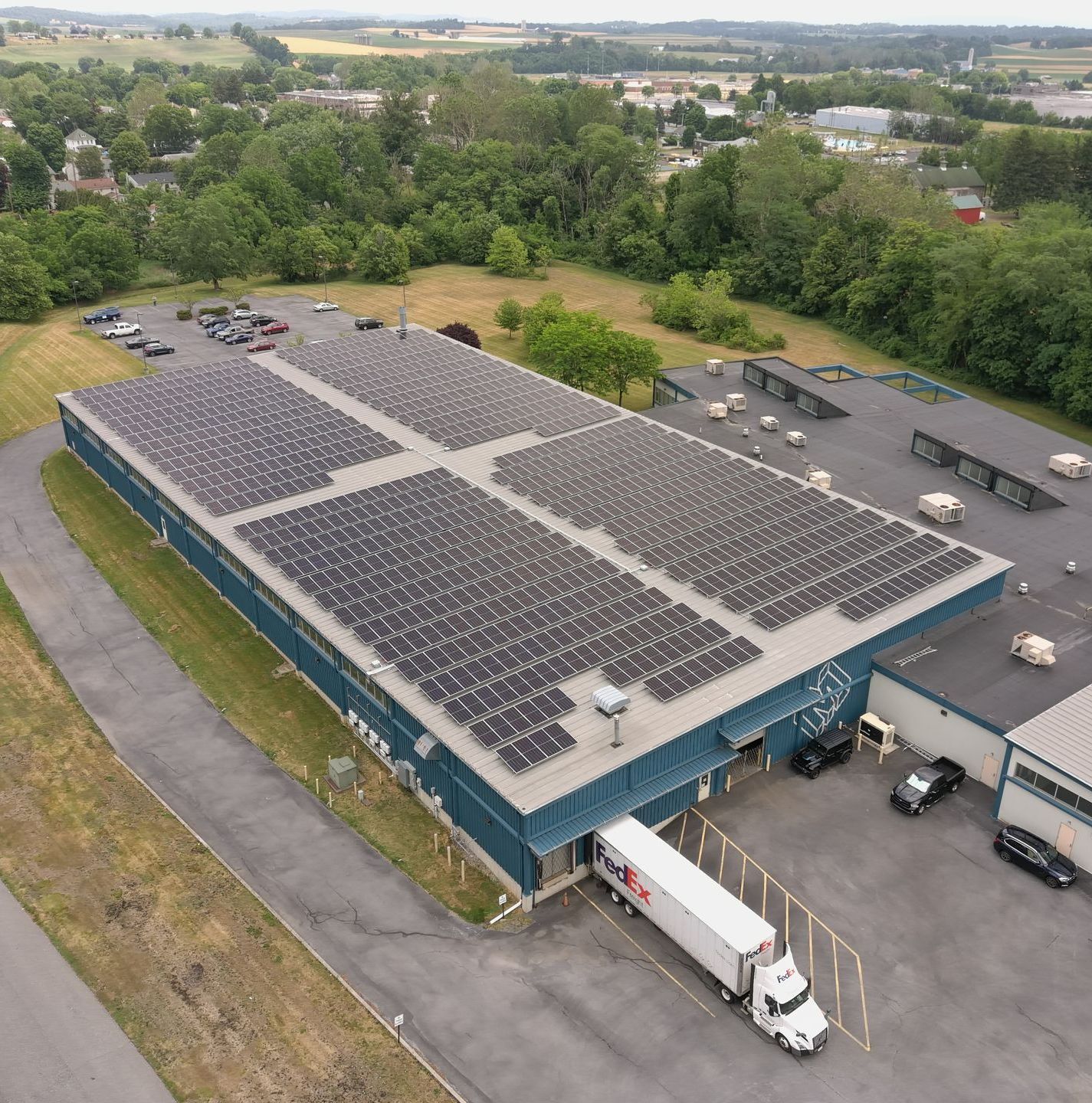 An aerial view of a large building with solar panels on the roof