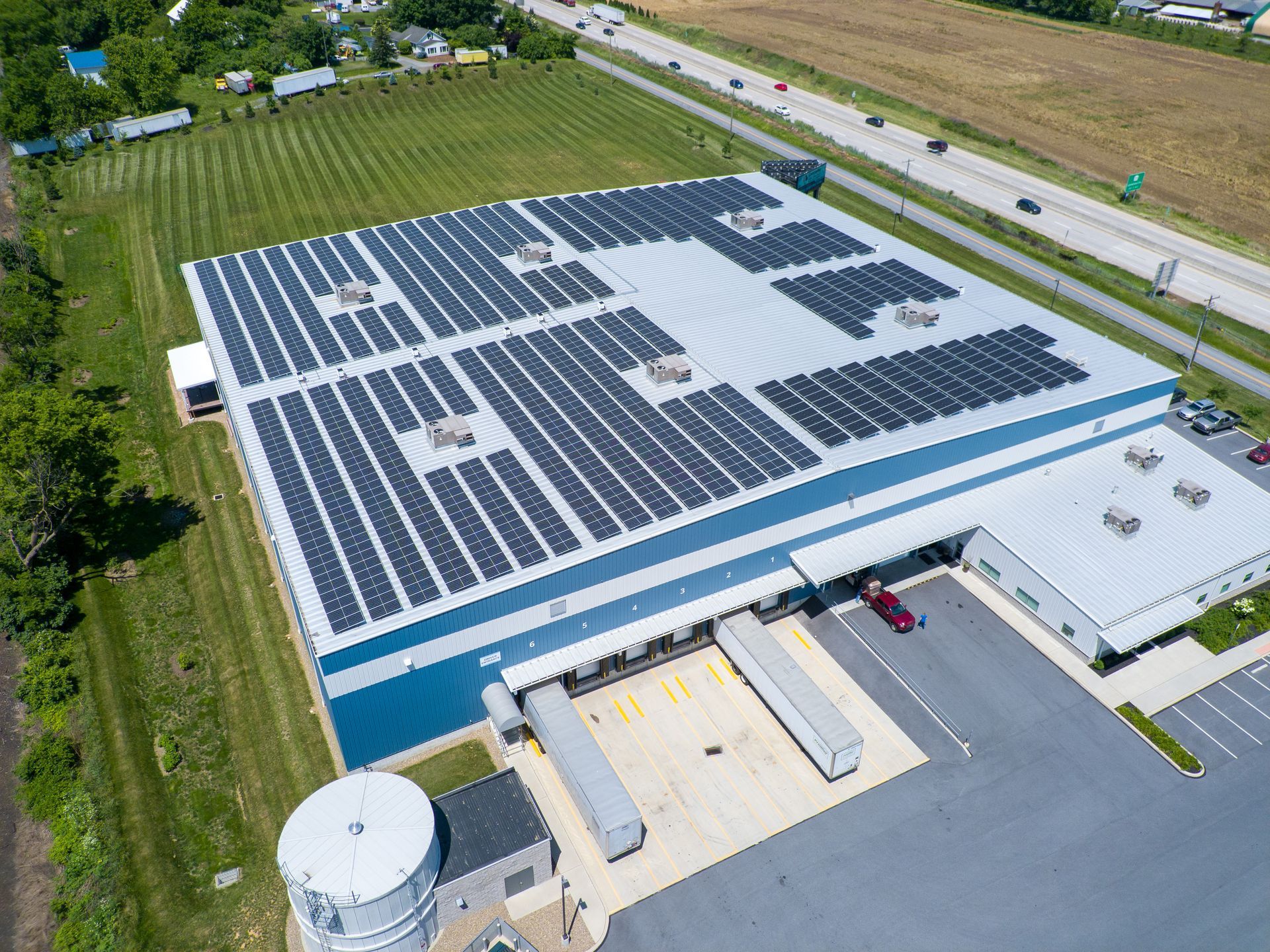 An aerial view of a large building with solar panels on the roof.