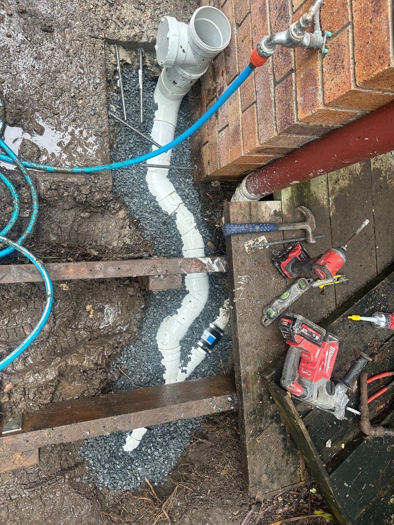A Drainpipe Being Installed Against a Brick Wall — Otto’s Plumbing & Gasfitting in McDowall, QLD