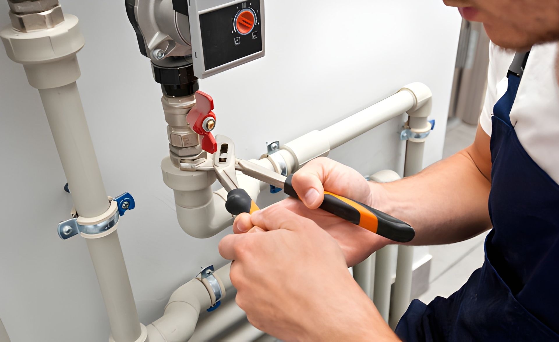 Plumber Using Pliers to Work on White Pipes — Otto’s Plumbing & Gasfitting in Kedron, QLD