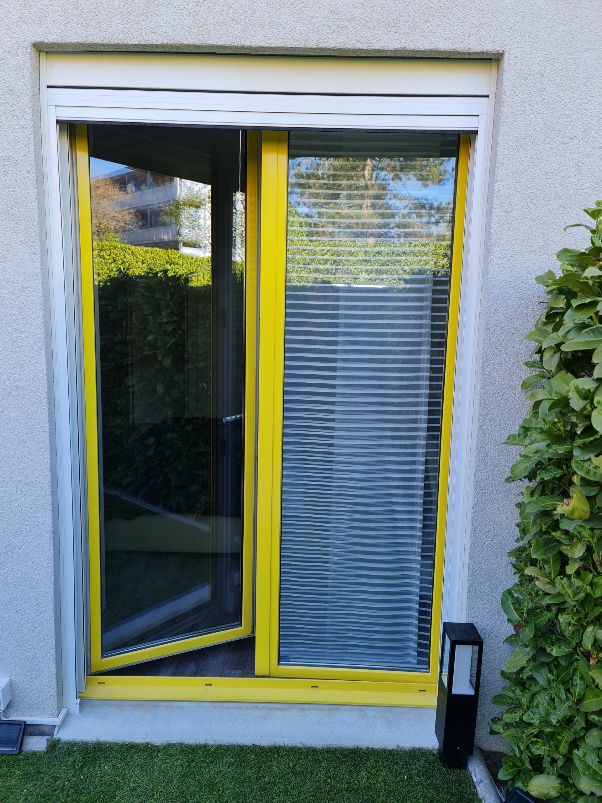 Détails de store à lamelles sur porte-fenêtre jaune