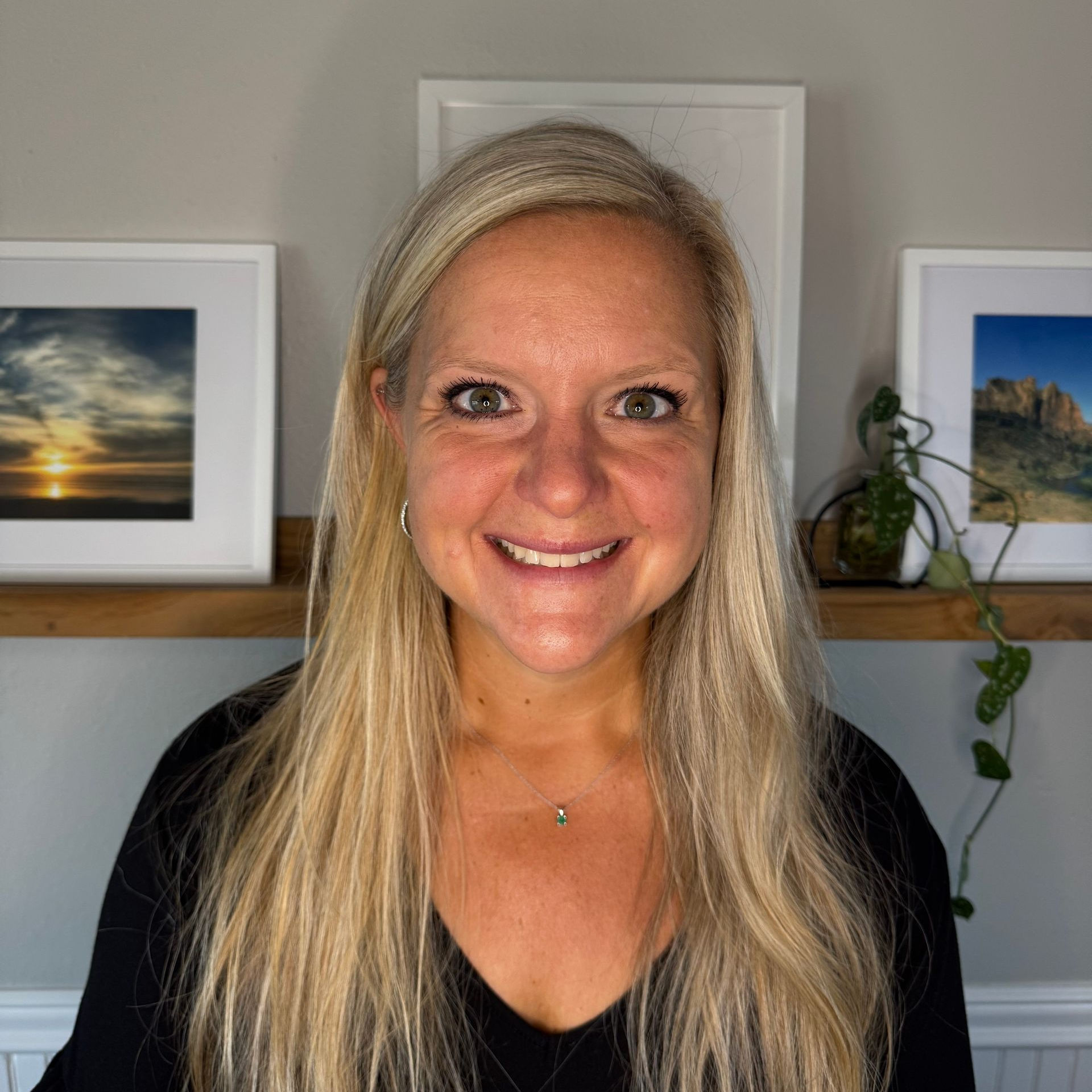 A woman wearing a black hoodie is smiling for the camera.