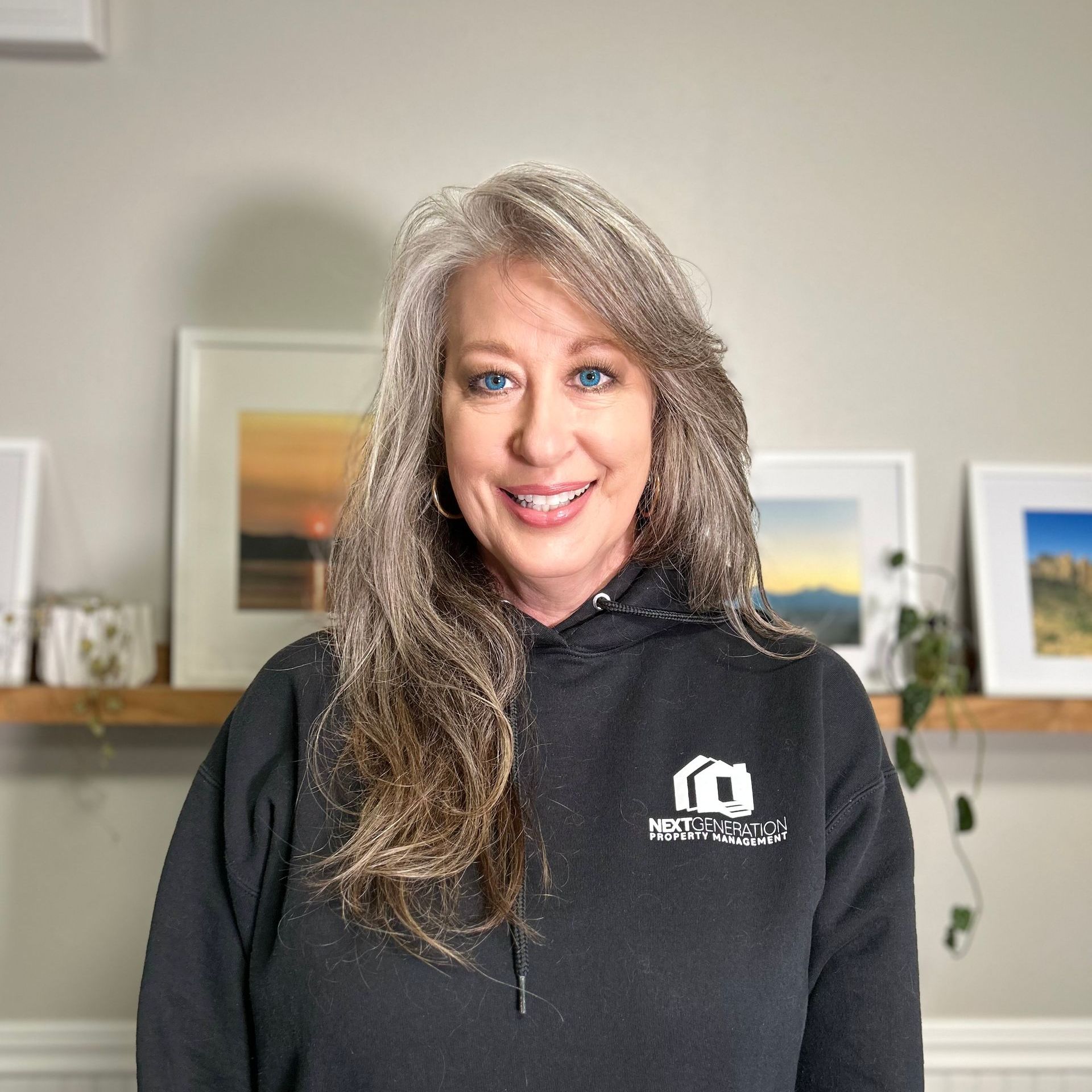 A woman wearing a black hoodie is smiling for the camera.