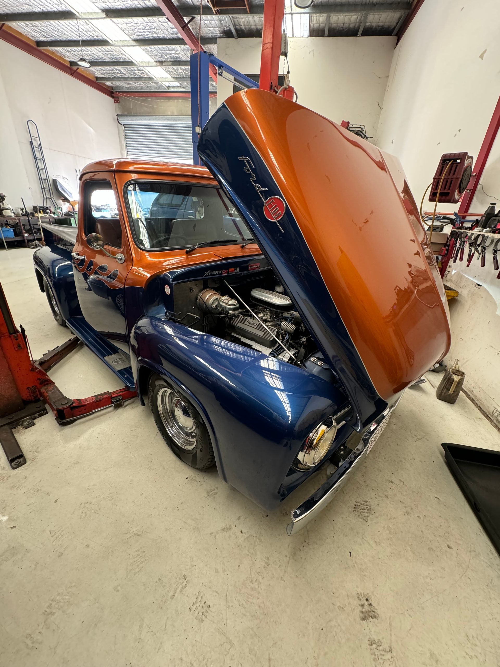 A blue and orange truck with the hood up in a garage. — HO Performance in Cleveland, QLD