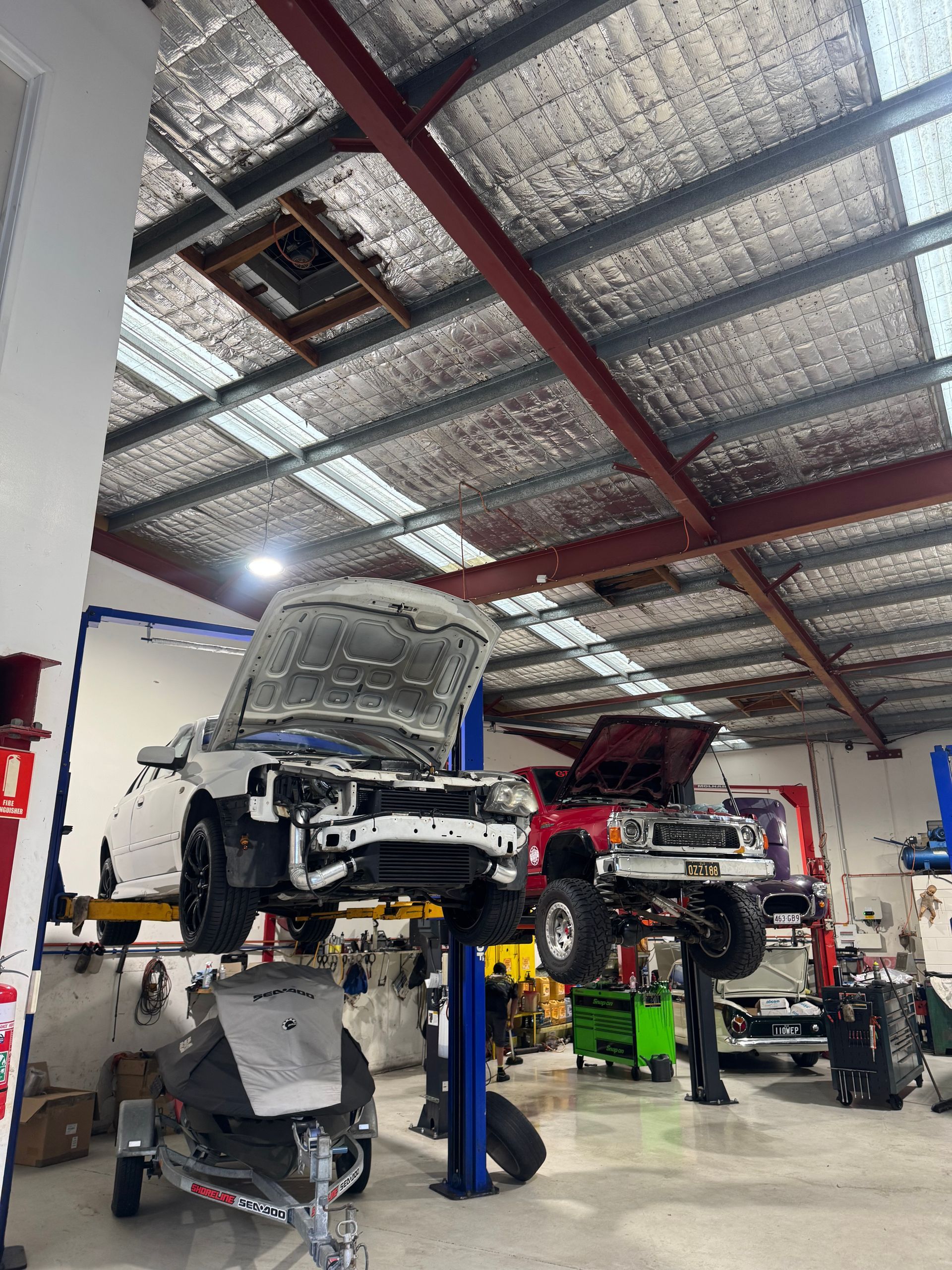 A car is sitting on a lift in a garage with its hood open. — HO Performance in Cleveland, QLD