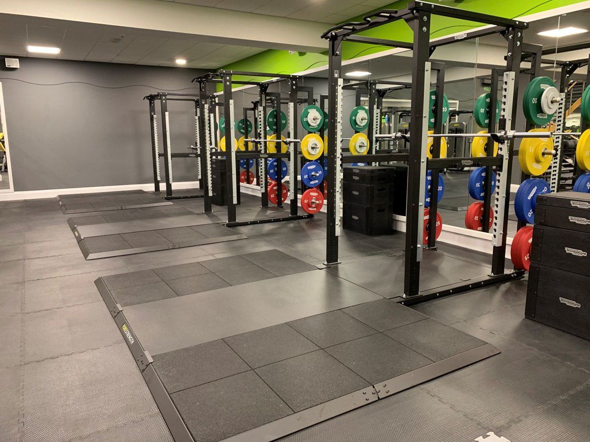 A gym with a lot of weights on the racks